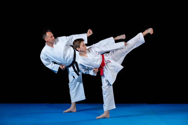Instructor de karate masculino entrenando a niños pequeños en dojo —  Fotos de Stock