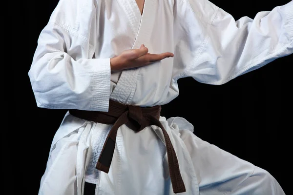 Joven niño entrenamiento karate en negro fondo — Foto de Stock