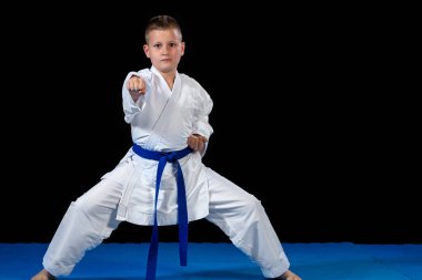 Pre-Teen Çocuk siyah bir zemin üzerine karate yapıyor