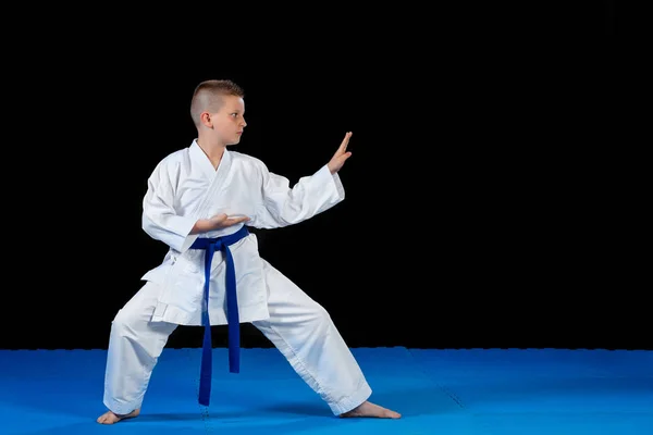 Pre-teen ragazzo fare karate su un nero sfondo — Foto Stock