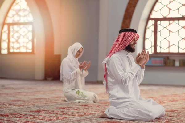 Muçulmano homem e mulher orando por Deus na mesquita juntos — Fotografia de Stock