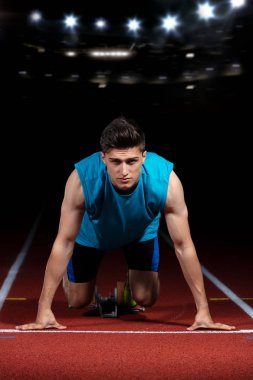 Işıkları ile koşu parkuru büyük modern Stadı önünde başlayan blok bırakarak sprinter. Patlayıcı Başlat.