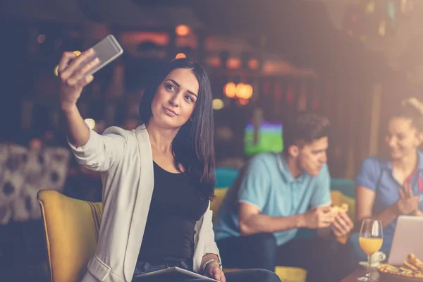 Woman taking selfie in front of her team in startup office — Stock Photo, Image