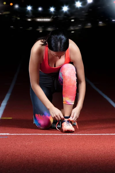 Athlete girl trying running shoes getting ready for race on track — Stock Photo, Image