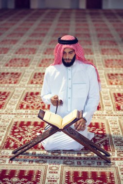 Dindar Müslüman adam caminin içinde dua ediyor.