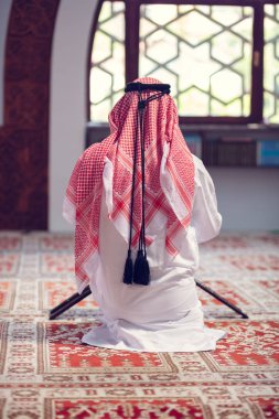 Dindar Müslüman adam caminin içinde dua ediyor.