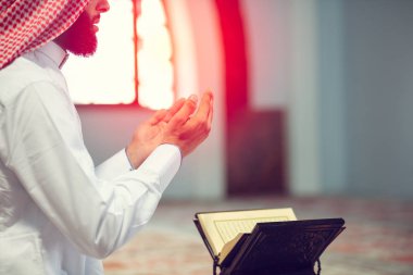 Dindar Müslüman adam caminin içinde dua ediyor.