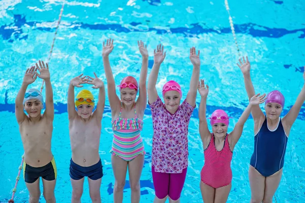 Glückliche Kindergruppe im Schwimmbad lernt schwimmen — Stockfoto