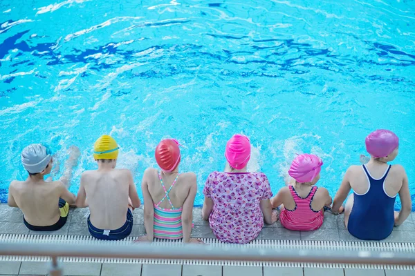 Bambini felici gruppo bambini a lezione di piscina imparare a nuotare — Foto Stock