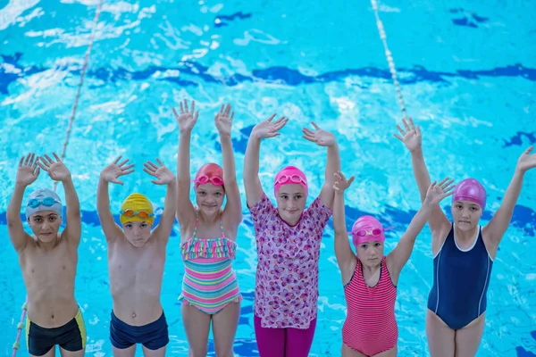 Glückliche Kindergruppe im Schwimmbad lernt schwimmen — Stockfoto