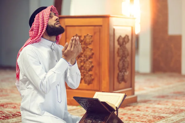 Dindar Müslüman adam caminin içinde dua ediyor.