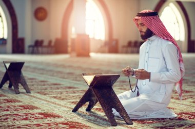 Dindar Müslüman adam caminin içinde dua ediyor.