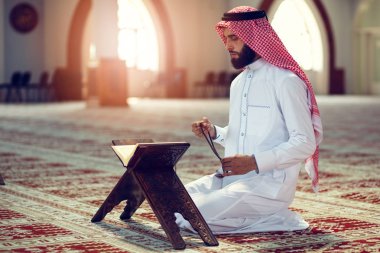 Dindar Müslüman adam caminin içinde dua ediyor.