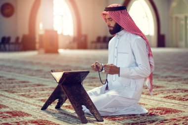 Dindar Müslüman adam caminin içinde dua ediyor.