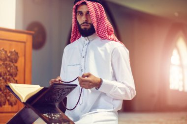 Dindar Müslüman adam caminin içinde dua ediyor.