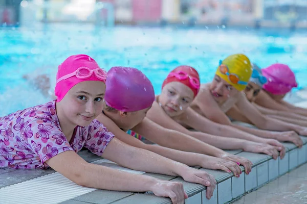 Glada barn vid poolen. unga och framgångsrika simmare pose. — Stockfoto