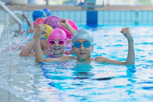 Niños felices en la piscina. nadadores jóvenes y exitosos posan . — Foto de Stock