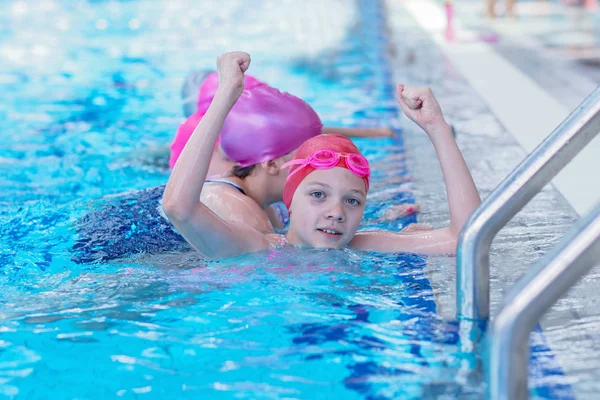 Glückliche Kinder im Schwimmbad. Junge und erfolgreiche Schwimmer posieren. — Stockfoto