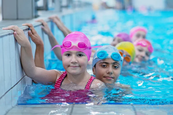 Gelukkige jonge geitjes bij het zwembad. jonge en succesvolle zwemmers pose. — Stockfoto