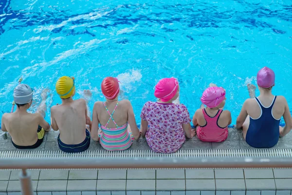 Glückliche Kindergruppe im Schwimmbad lernt schwimmen — Stockfoto