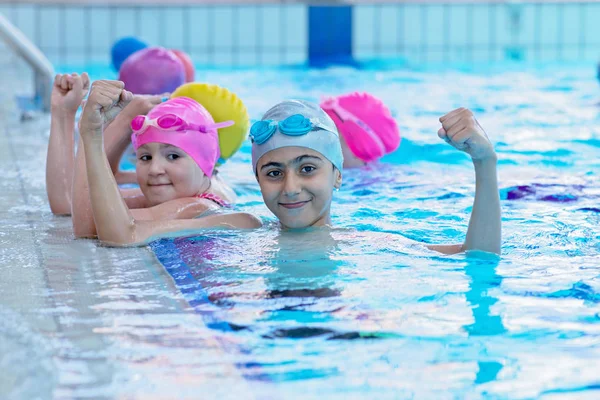 Gelukkige jonge geitjes bij het zwembad. jonge en succesvolle zwemmers pose. — Stockfoto