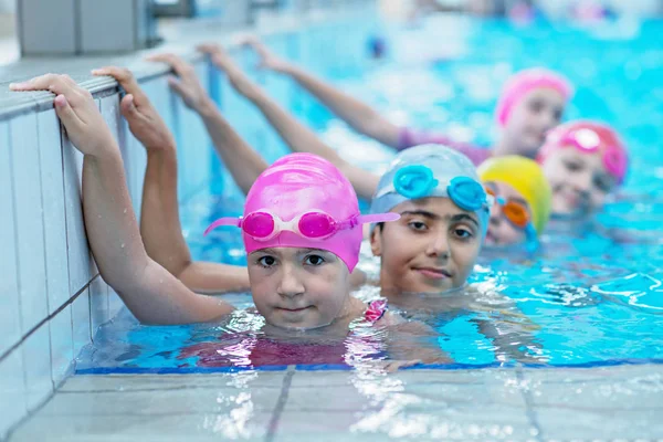 Niños felices en la piscina. nadadores jóvenes y exitosos posan . — Foto de Stock