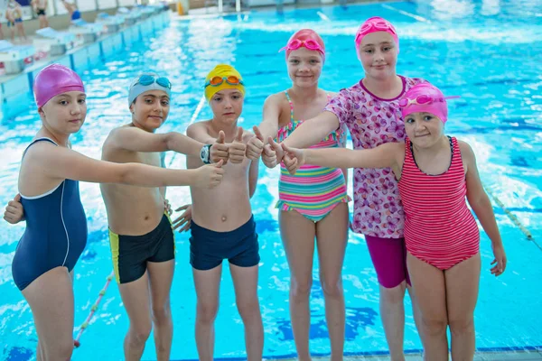 स्विमिंग पूल क्लास में खुश बच्चों बच्चों समूह तैरने के लिए सीखना — स्टॉक फ़ोटो, इमेज