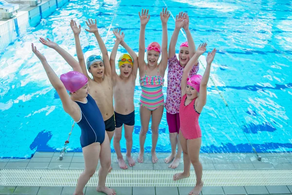 Niños felices grupo de niños en la clase de piscina aprender a nadar —  Fotos de Stock