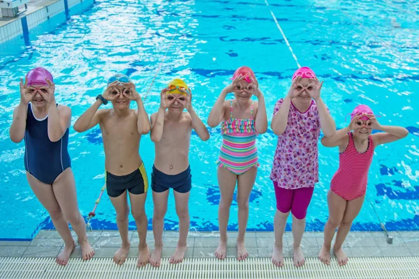 Crianças felizes grupo de crianças na aula de piscina aprender a nadar — Fotografia de Stock