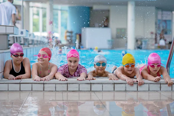 Glada barn vid poolen. unga och framgångsrika simmare pose. — Stockfoto