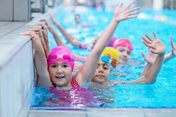 Glada barn vid poolen. unga och framgångsrika simmare pose. — Stockfoto