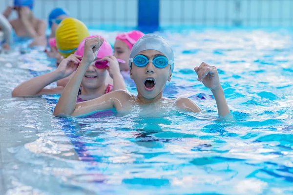 Glückliche Kinder im Schwimmbad. Junge und erfolgreiche Schwimmer posieren. — Stockfoto