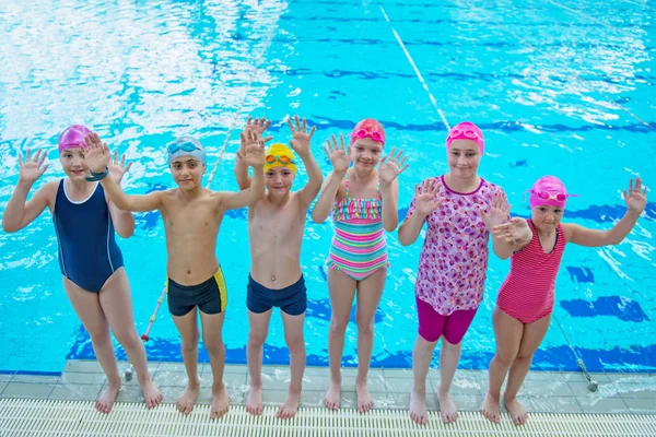 Glada barn barn gruppen vid poolen klass att lära sig att simma — Stockfoto