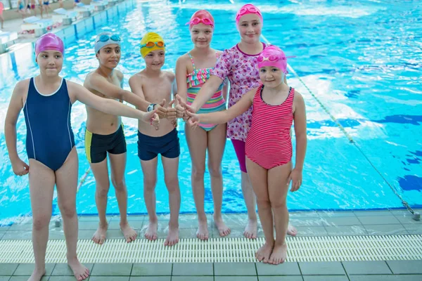 Glada barn barn gruppen vid poolen klass att lära sig att simma — Stockfoto