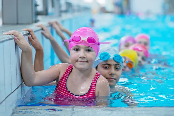 Niños felices en la piscina. nadadores jóvenes y exitosos posan . —  Fotos de Stock