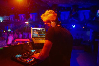 Kulüp, disko DJ 'i mutlu insanlar için müzik çalıp karıştırıyor. Gece hayatı, konser ışıkları, fişekler..