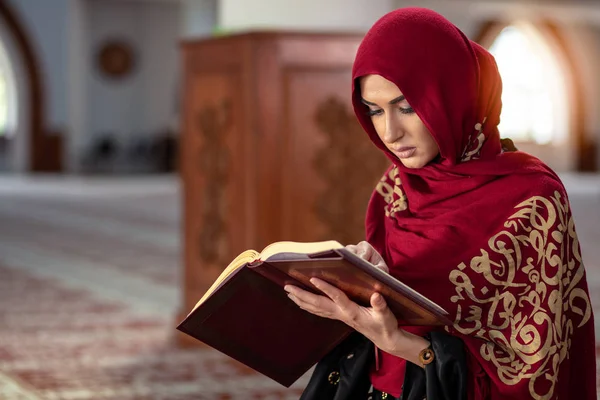 Jonge moslimvrouw bidden in moskee met quran — Stockfoto