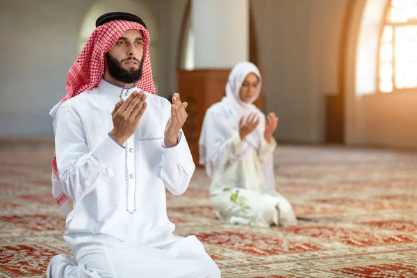 Мусульманский мужчина и женщина молятся в мечети — стоковое фото