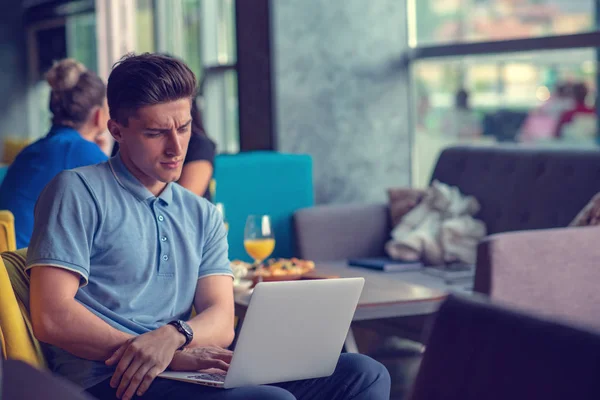 Young skilled male freelancer starting working day early in morning drinking coffee to wake up — Stock Photo, Image