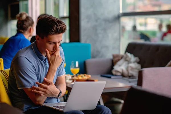 Giovane freelance maschio qualificato che inizia la giornata lavorativa presto al mattino bevendo caffè per svegliarsi — Foto Stock