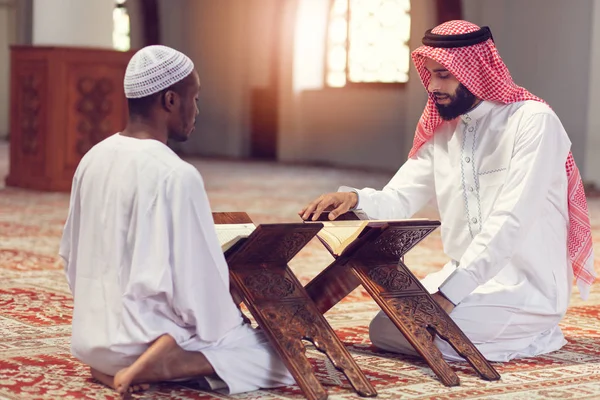 Muslimska män ber med heliga böcker i moskén — Stockfoto