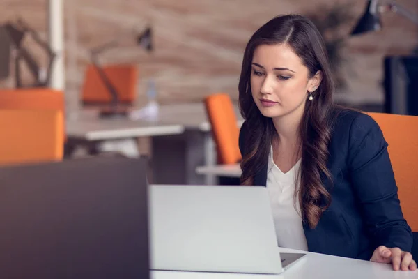 Digitando messaggio aziendale. Giovane donna sicura di sé in abbigliamento casual intelligente che tiene lo smartphone e lo guarda con sorriso — Foto Stock