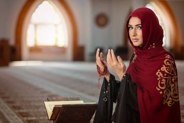 Молодая молящаяся женщина падает на колени в мечети — стоковое фото