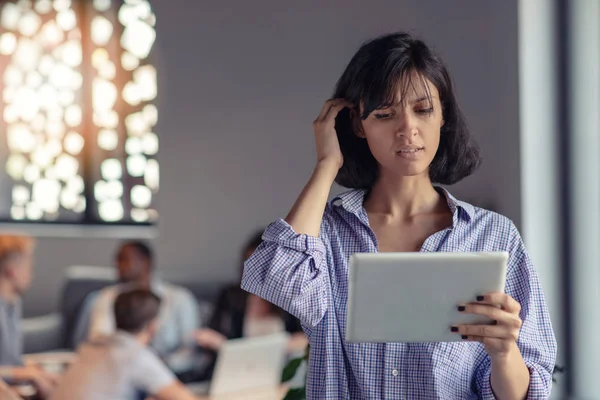 Portrait of smiling woman in office with tablet