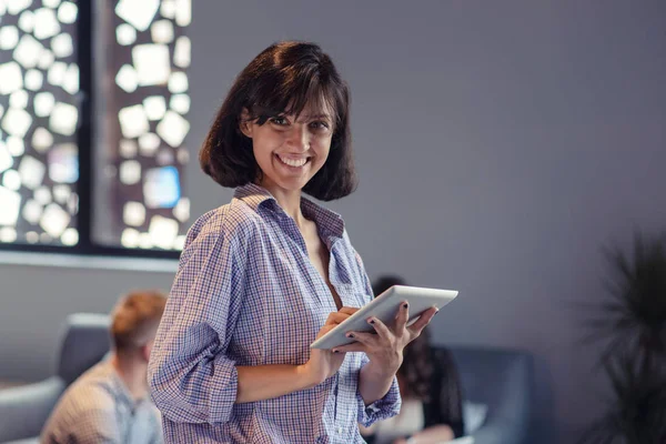 Portrait of smiling woman in office with tablet