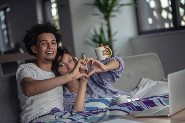 Jovem atraente casal diverso navegando na internet, usando computador portátil, sorrindo . — Fotografia de Stock