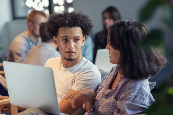 Negocio de puesta en marcha y nuevo concepto de tecnología móvil con joven pareja multiétnica en el interior de la oficina brillante moderna que trabaja en el ordenador portátil y tableta en el nuevo proyecto creativo y lluvia de ideas —  Fotos de Stock