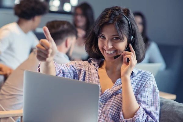 Beautiful phone operator Arab woman working in modern startup office