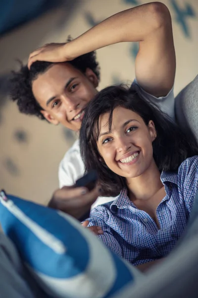 Beskuren bild av en ung amerikansk par tittar på TV hemma — Stockfoto