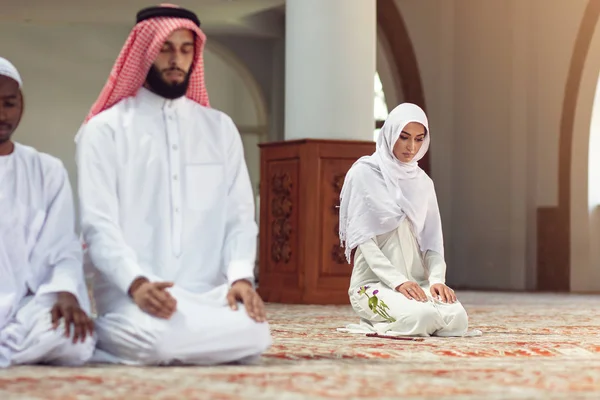 Muslimska män ber med heliga böcker i moskén — Stockfoto